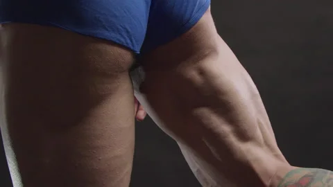 Bodybuilder demonstrates the muscles of the back of the thigh Stock Footage 175172956