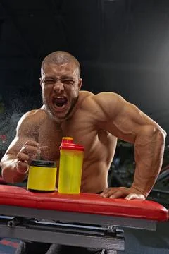 Bodybuilder demonstrating workout intensity and energy during training session Stock Photos