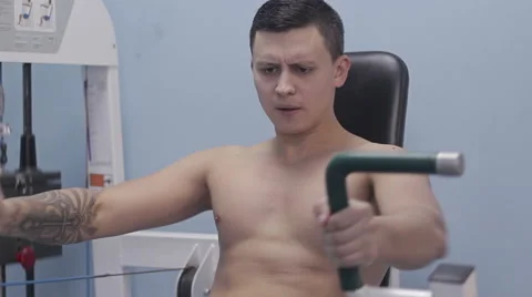 Bodybuilder doing exercises on chest sitting in the simulator Stock Footage 57281468