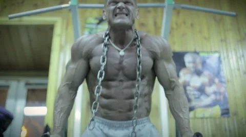 Bodybuilder doing push-ups on exercise bars in the gym Stock Footage 57992862
