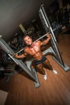 Bodybuilder doing squat with barbell Stock Photos