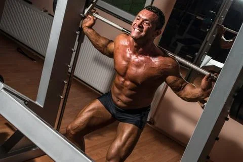 Bodybuilder doing squat with barbell Stock Photos