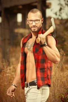Bodybuilder with double edge axe posing and working out Stock Photos