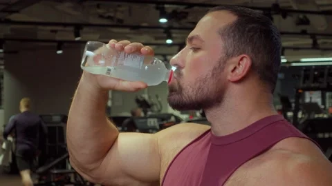 Bodybuilder drinks water from bottle after sports workout in the gym. Healthy Video stock 194357200
