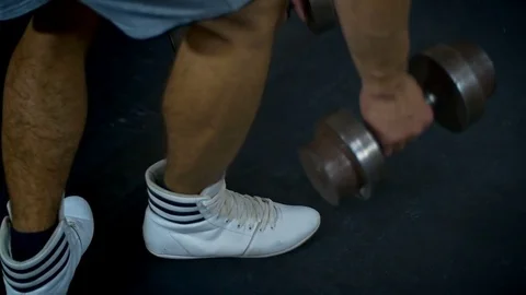 The bodybuilder drop down a dumbbell. The dumbbells are laying on floor in gym Video stock 81416194