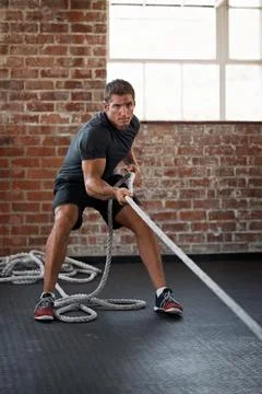 Bodybuilder, exercise and man with battle rope in gym, pull or training for Stock Photos