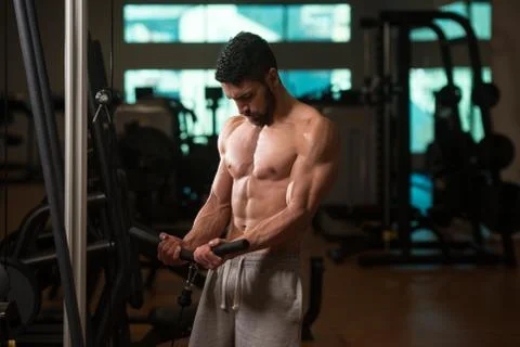 Bodybuilder Exercising Biceps On Machine Stock Photos