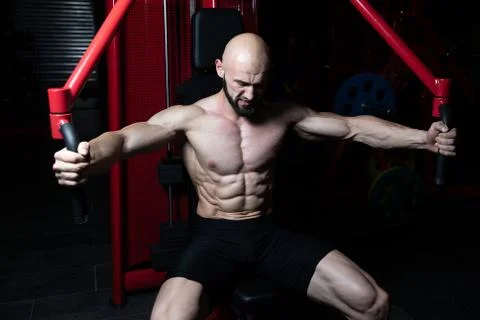 Bodybuilder Exercising Chest On Machine Stock Photos