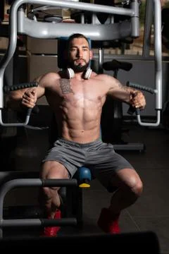 Bodybuilder Exercising Chest On Machine Stock Photos