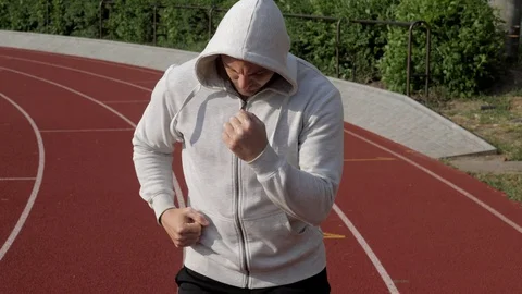 Bodybuilder exercising on the fresh air on a stadium in the sunset Stock Footage 130168124
