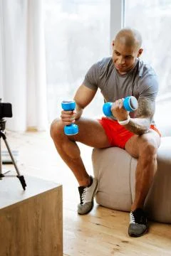 Bodybuilder filming tutorial about exercises with hand weights 스톡 사진