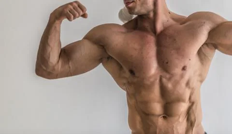Bodybuilder flexing his muscles in studio. The torso of attractive male body  Stock Photos