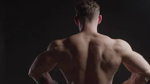 Bodybuilder in glasses strains his back muscles Video stock 172151674