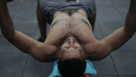 Bodybuilder lifting heavy barbell weights against. Stock Footage 101338062
