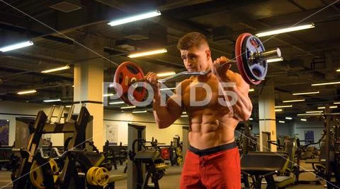 Bodybuilder man doing exercise on biceps with barbell Stock Photos