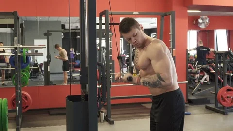 Bodybuilder man doing triceps pull in the gym Stock Footage 73917848