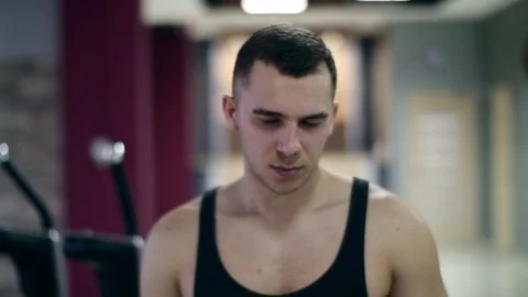 Bodybuilder man is going in a gym hall Stock Footage 75497714