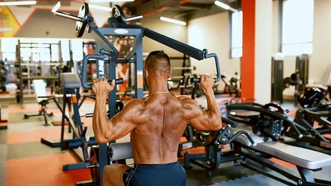 Bodybuilder man hard training muscles at training machine. Stock Footage 81481338