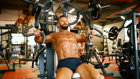 Bodybuilder man hard training muscles at training machine. Stock Footage 81489667