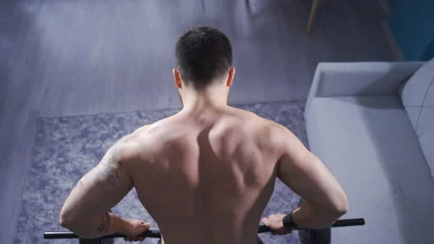 Bodybuilder man working out at home using weights for back and arm muscles. Stock Footage 232278772