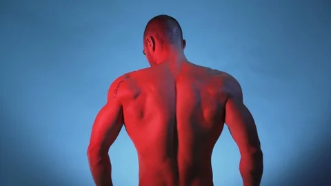 Bodybuilder Performing Rear Lat Spread Pose and posing for studio session Stock Footage 118132237