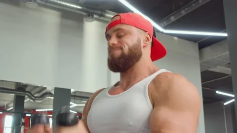 Bodybuilder performs exercise in biceps simulator in the gym. Sports training Video stock 188014298