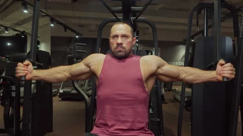 Bodybuilder performs an exercise on the chest muscles on a simulator in the gym Video stock 189952083