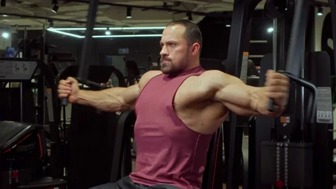 Bodybuilder performs an exercise on the chest muscles on a simulator in the gym Video stock 189954874