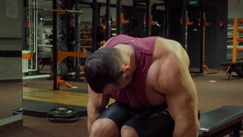 Bodybuilder performs exercise with dumbbells on muscles of the back and triceps Stock Footage 185633028