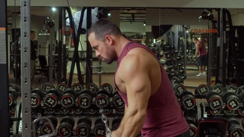 Bodybuilder performs exercise in triceps simulator in the gym. Sports training Video stock 185632170