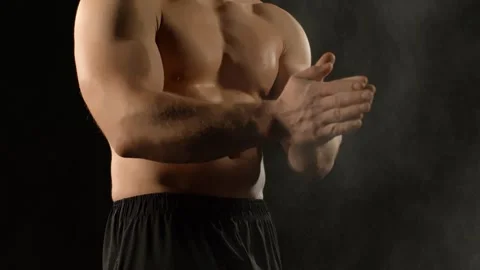 A bodybuilder poses against a black background Stock Footage 323389032