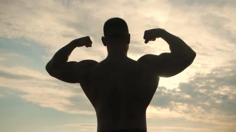 Bodybuilder poses with his back to the camera. Back Double biceps on the sun Stock Footage 200118139