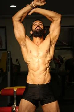 Bodybuilder posing in different poses demonstrating their muscles. Stock Photos