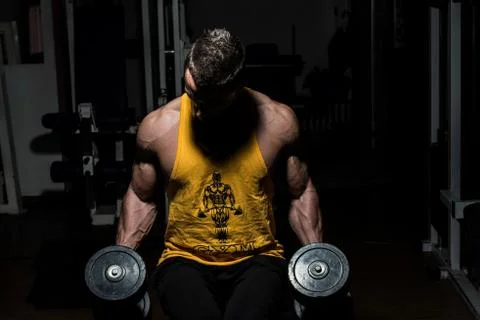 Bodybuilder posing with dumbbells Stock Photos