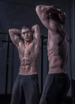 Bodybuilder posing, looking at himself, double mirror image Stock Photos