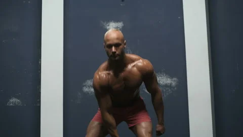 Bodybuilder pumping up muscles with kettlebell Vídeos de archivo 131381986
