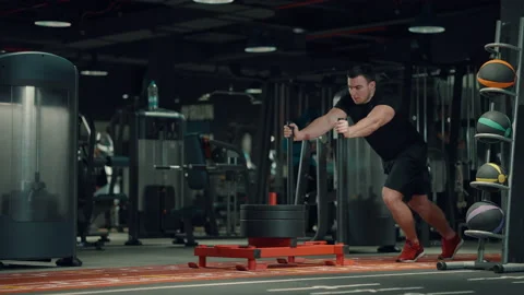 Bodybuilder pushing stand with weights in gym Stock Footage 148461145