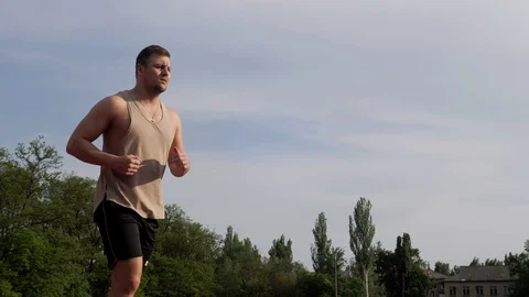 Bodybuilder running and jogging on the fresh air on a race track outdoors Stock Footage 130168279