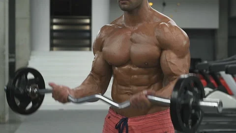 Bodybuilder strong man pumping up biceps muscles Video stock 131385325