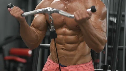Bodybuilder strong man pumping up biceps muscles Vídeos de archivo 131385571