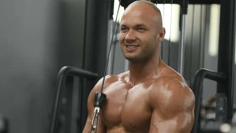 Bodybuilder strong man pumping up triceps muscles Video stock 131384981