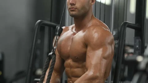 Bodybuilder strong man pumping up triceps muscles Video stock 131387150