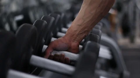 Bodybuilder takes the dumbbell. Stock Footage 76969953