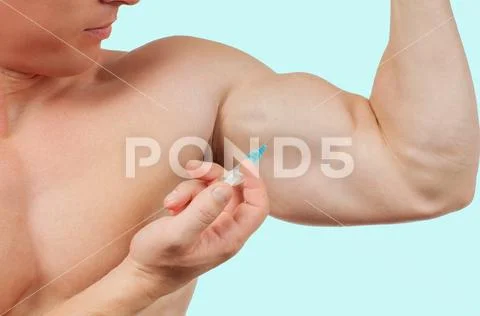 Bodybuilder taking steroids injection in arm on blue background. Stock Photos