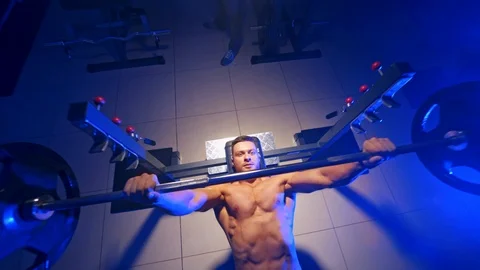 Bodybuilder trainer man doing bench press workout in gym. Video from the top. Video stock 119152740