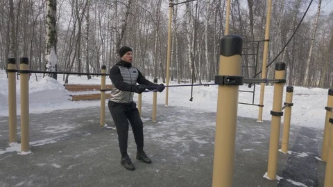 Bodybuilder training anaerobic exercise with expander on outdoor winter training Stock Footage 87893036