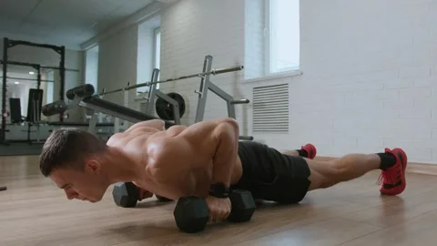 Bodybuilder training in gym and performs a dumbbell bench press in exercise 库存影片 270913749