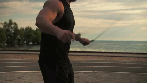 Bodybuilder training on the outdoors doing the exercise of jumping rope  Stock Footage 200118298