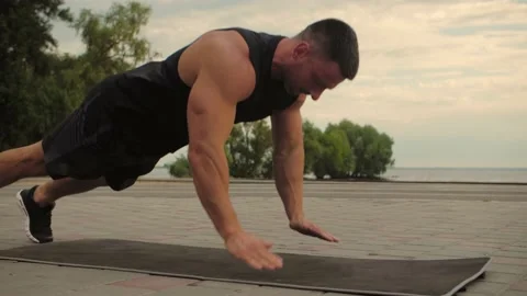 Bodybuilder training outdoors doing push-ups with hands clapping. Close-up.  Stock Footage 200118451