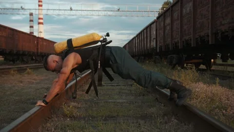 Bodybuilder training at the railway yard and moves along the rails in the 库存影片 218431040